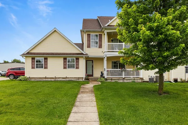 a front view of a house with a yard and trees