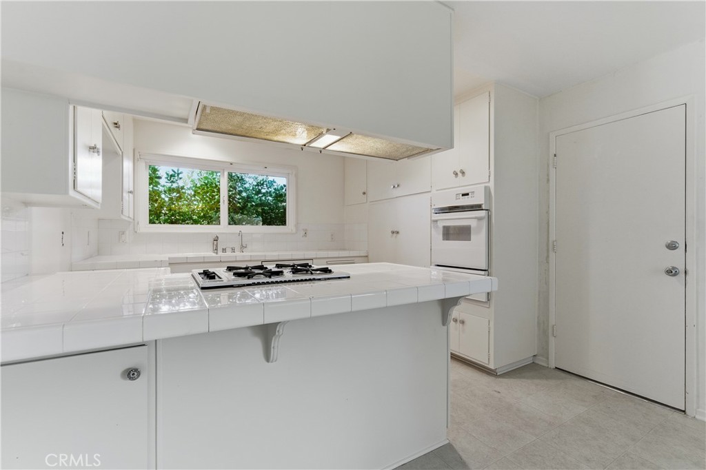 26136 Veva Way Calabasas, CA 91302 - Photo 5 of 22 a kitchen with granite countertop a sink stove and refrigerator