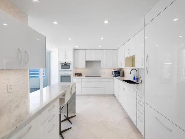 a kitchen with granite countertop white cabinets white stainless steel appliances and sink