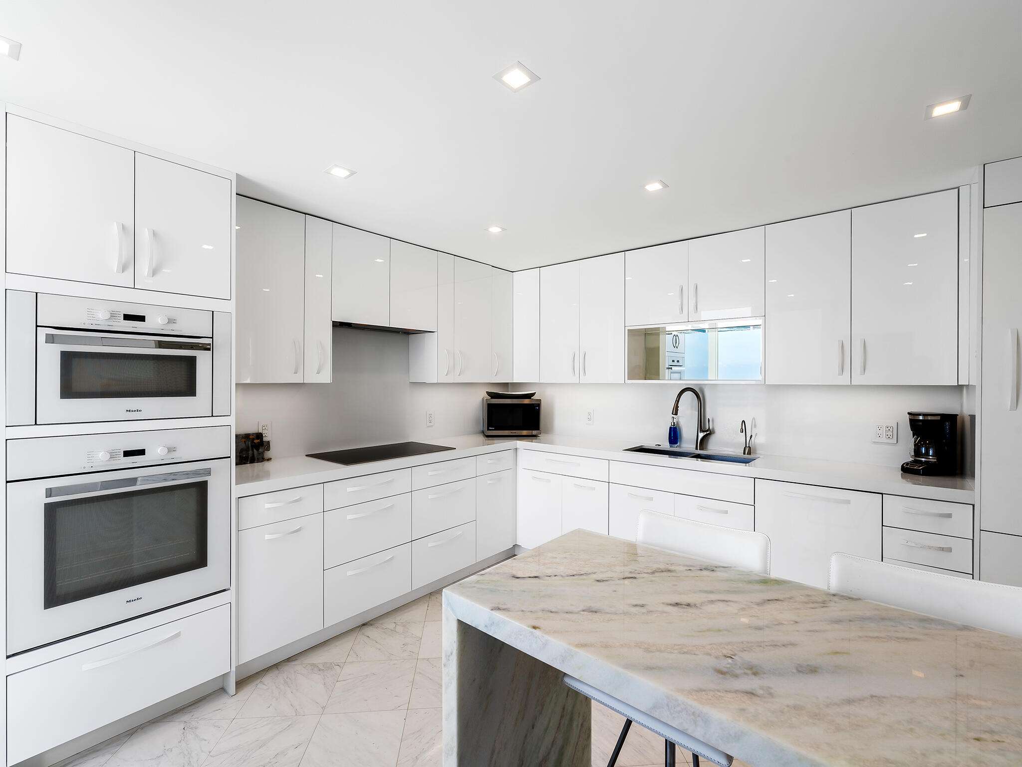3407 South Ocean Boulevard, Unit PHB Highland Beach, FL 33487 - Photo 13 of 49 a kitchen with granite countertop white cabinets white stainless steel appliances and sink