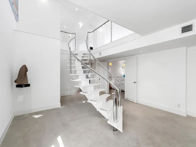 a spacious bedroom with a bed and a large window