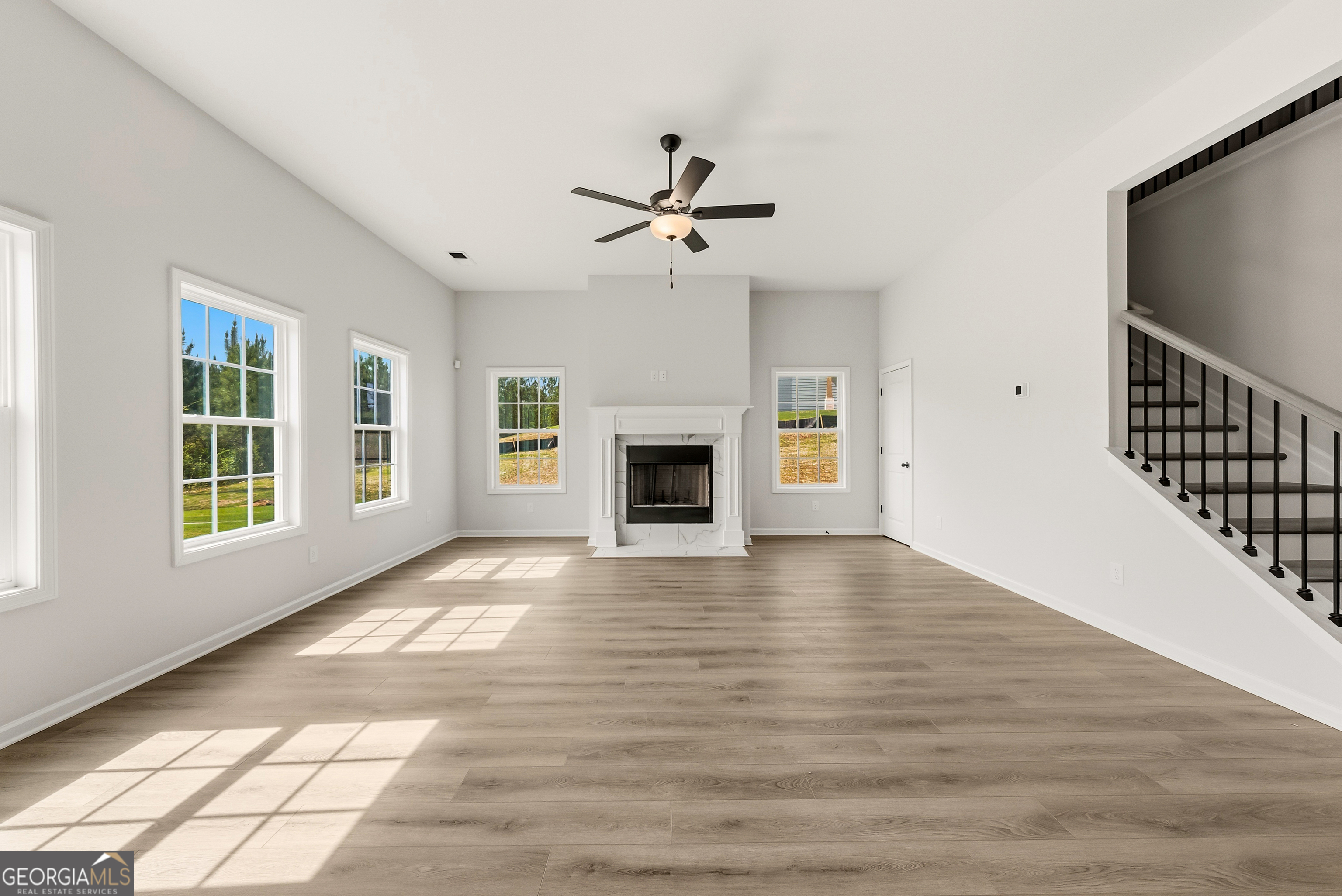110 Hawkeye Trail, Unit 83 Fortson, GA 31808 - Photo 15 of 43 an empty room with windows fireplace and a kitchen view