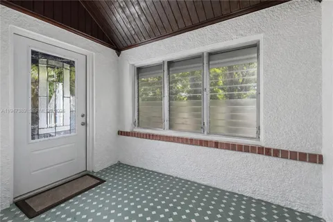 a view of a room that has a window and wooden floor