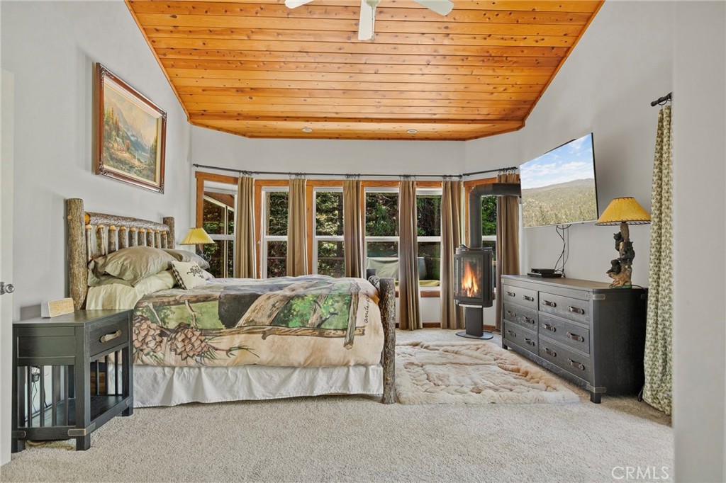 523 Dogwood Canyon Road Blue Jay, CA 92317 - Photo 15 of 33 a spacious bedroom with a large bed and a chandelier