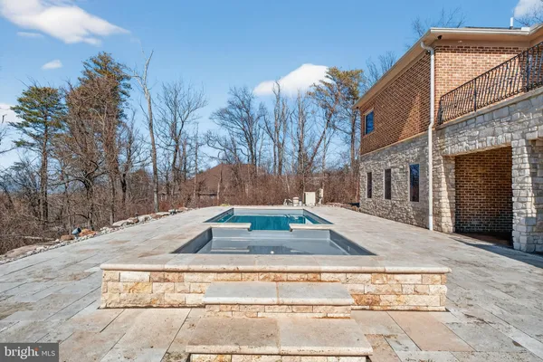 a view of a livingroom with a fireplace a ceiling fan and wooden floor