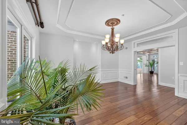 a view of an empty room with wooden floor and a fireplace