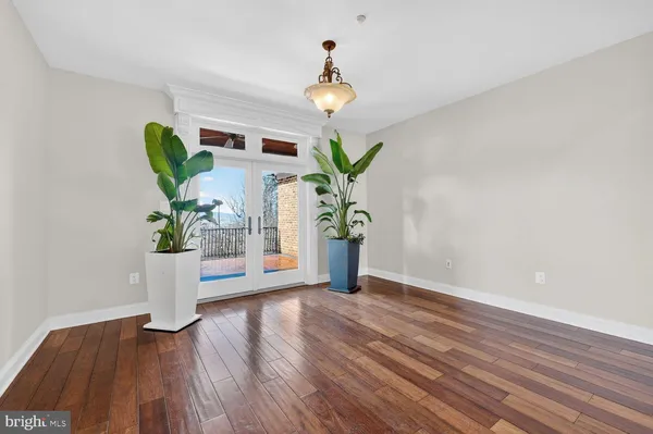 a view of the room with wooden floor and windows