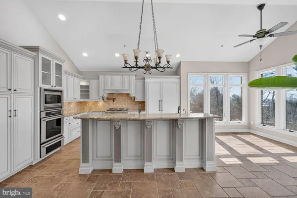 a kitchen with white cabinets and refrigerator
