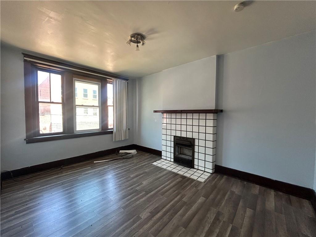815 Broadway Avenue McKees Rocks, PA 15136 - Photo 4 of 7 an empty room with wooden floor fireplace and windows