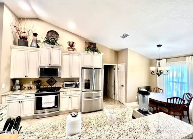 a kitchen with a refrigerator and a stove top oven