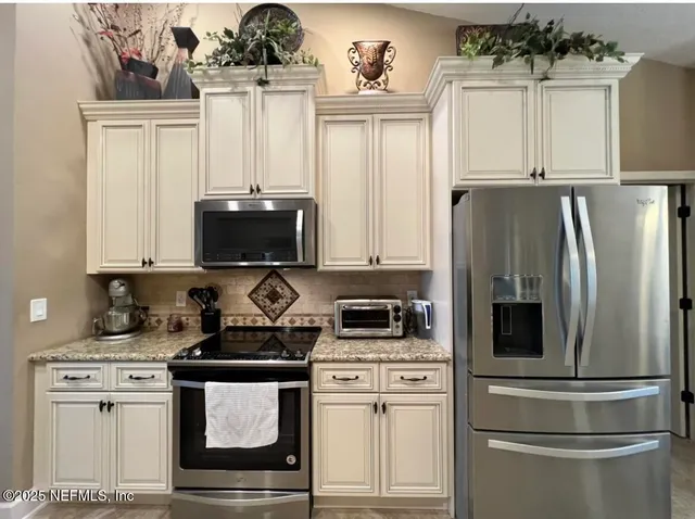 a kitchen with stainless steel appliances a refrigerator stove and microwave