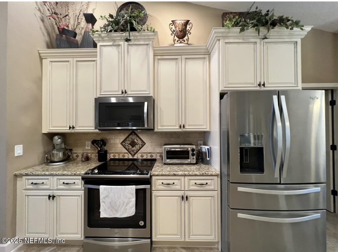 1024 Ardmore Street St. Augustine, FL 32092 - Photo 12 of 25 a kitchen with stainless steel appliances a refrigerator stove and microwave