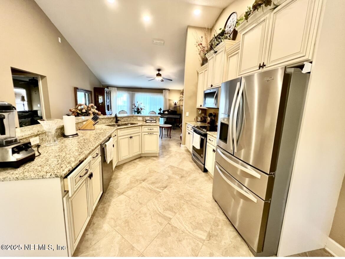 1024 Ardmore Street St. Augustine, FL 32092 - Photo 13 of 25 a kitchen with stainless steel appliances granite countertop a refrigerator a stove a sink and a dining table