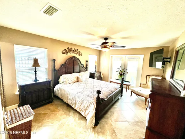 a spacious bedroom with a bed and wooden floor