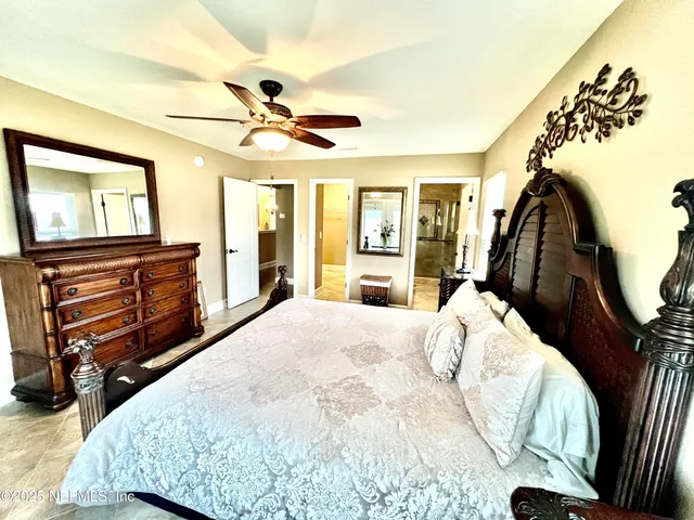 a bedroom with a bed and a flat tv screen on dresser