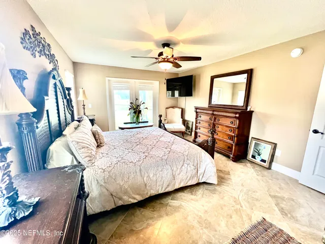 a bedroom with a bed wooden floor and ceiling fan