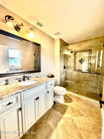 a bathroom with a sink vanity granite and toilet