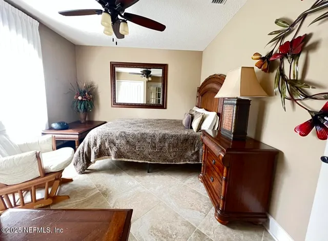 a bedroom with a bed a window and dresser