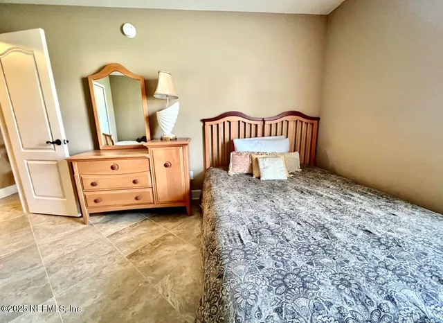 a spacious bedroom with a bed and a dresser