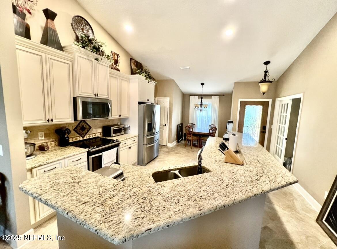 1024 Ardmore Street St. Augustine, FL 32092 - Photo 10 of 25 a kitchen with stainless steel appliances granite countertop a sink refrigerator stove and microwave