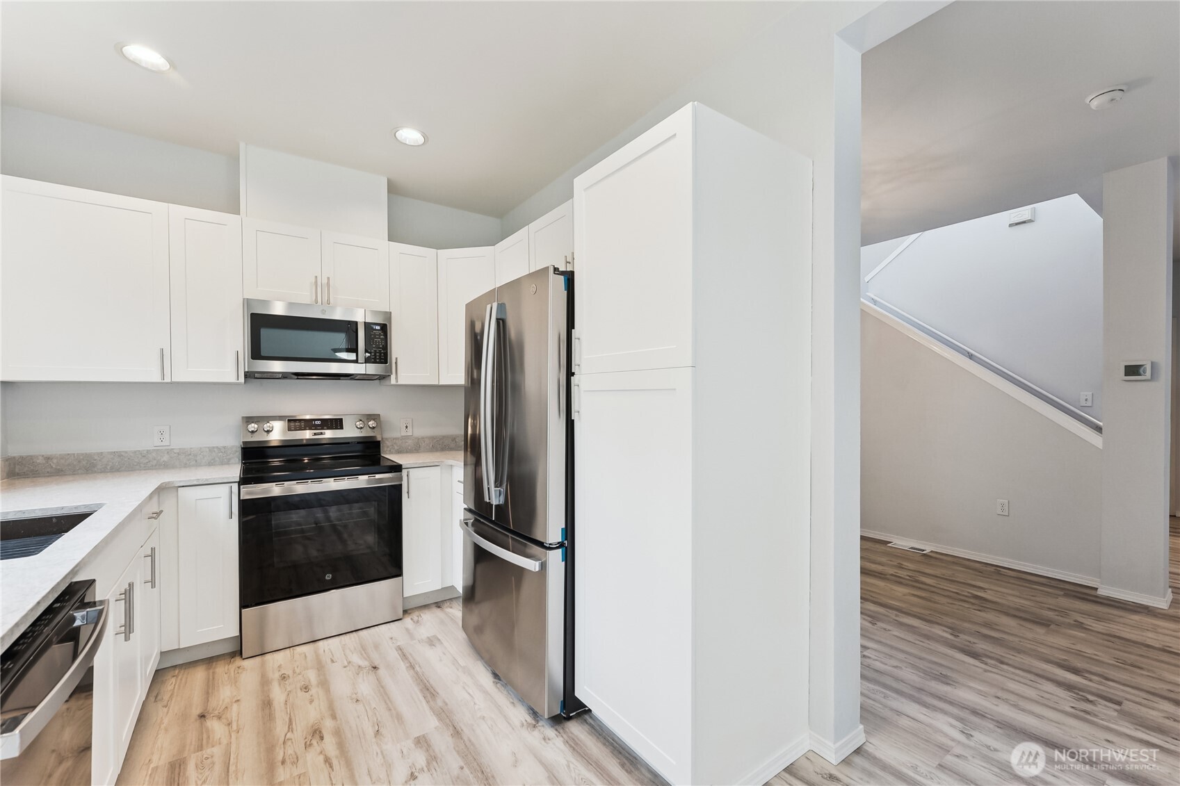 405 South 47th Street, Unit 405 Renton, WA 98055 - Photo 11 of 30 a kitchen with a refrigerator sink and wooden floor