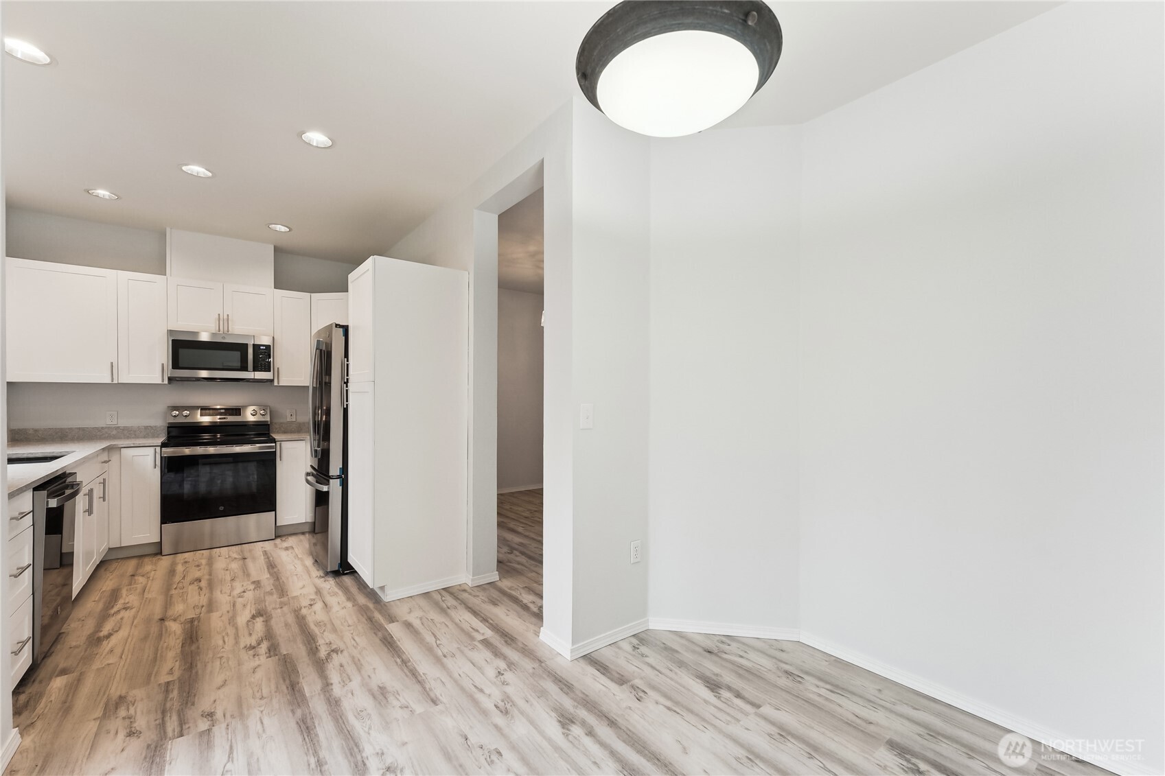 405 South 47th Street, Unit 405 Renton, WA 98055 - Photo 13 of 30 a kitchen with a refrigerator a stove top oven and wooden floor