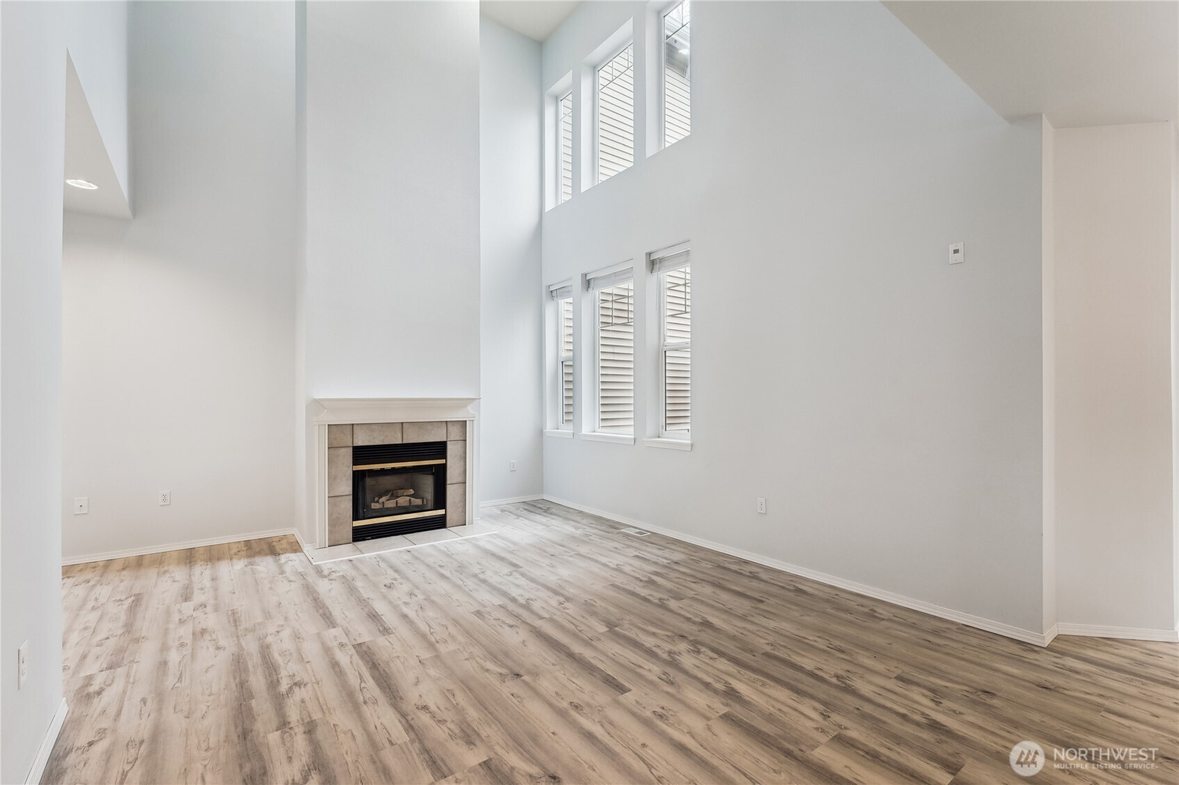405 South 47th Street, Unit 405 Renton, WA 98055 - Photo 3 of 30 a view of an empty room with wooden floor fireplace and a window