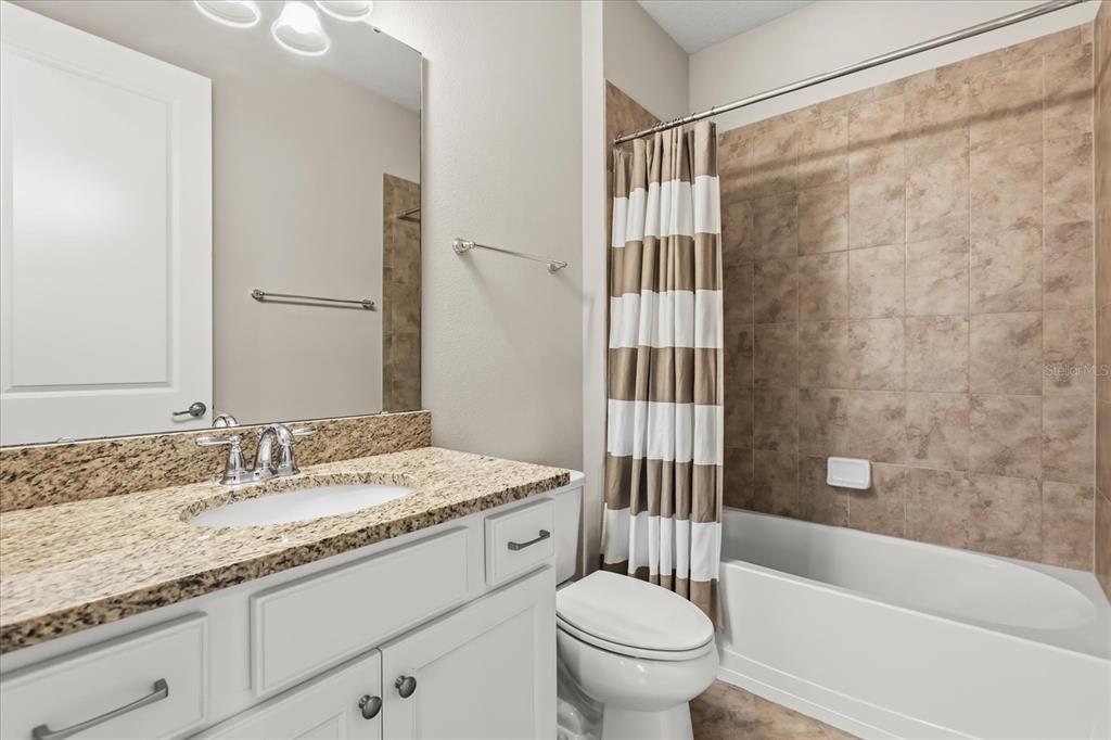 10713 BERRY CREEK Road Orlando, FL 32836 - Photo 30 of 60 a bathroom with a granite countertop sink toilet and shower