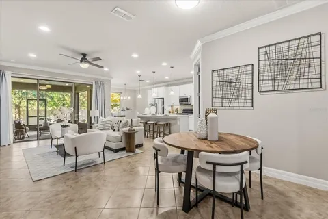 a living room with furniture and a large window with kitchen view