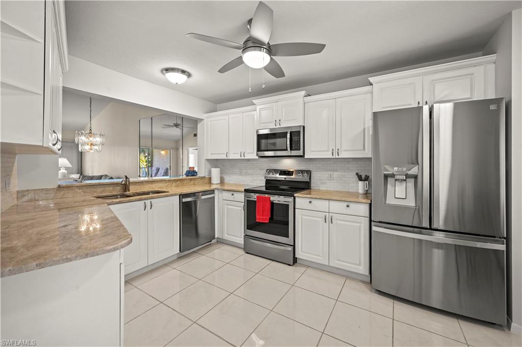 249 Gabriel Circle, Unit 12 Naples, FL 34104 - Photo 11 of 40 a kitchen with cabinets stainless steel appliances and a counter top space