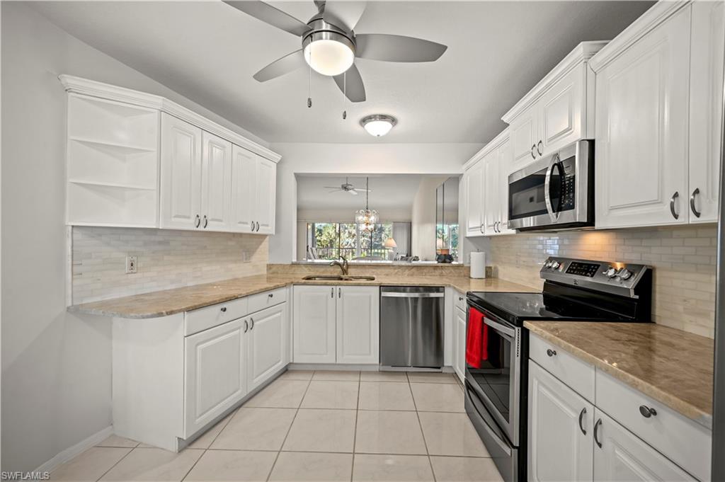 249 Gabriel Circle, Unit 12 Naples, FL 34104 - Photo 12 of 40 a kitchen with a sink cabinets and stainless steel appliances