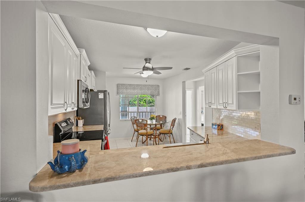 249 Gabriel Circle, Unit 12 Naples, FL 34104 - Photo 13 of 40 a dining room with furniture and a chandelier