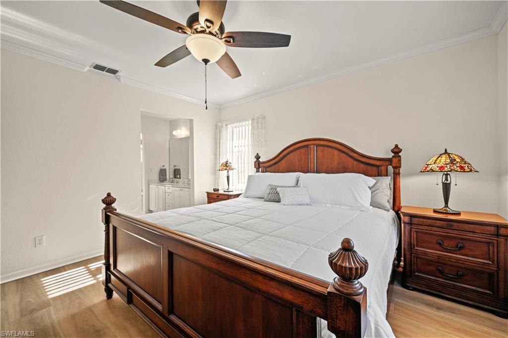 249 Gabriel Circle, Unit 12 Naples, FL 34104 - Photo 15 of 40 a bedroom with a bed and a chandelier