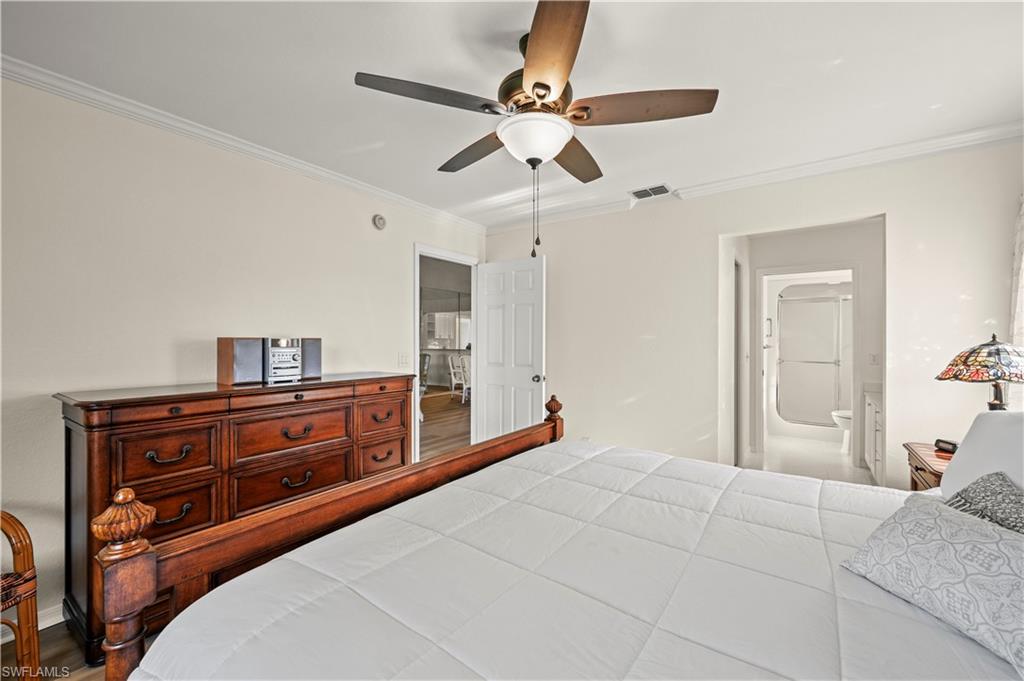 249 Gabriel Circle, Unit 12 Naples, FL 34104 - Photo 16 of 40 a bedroom with a bed and ceiling fan
