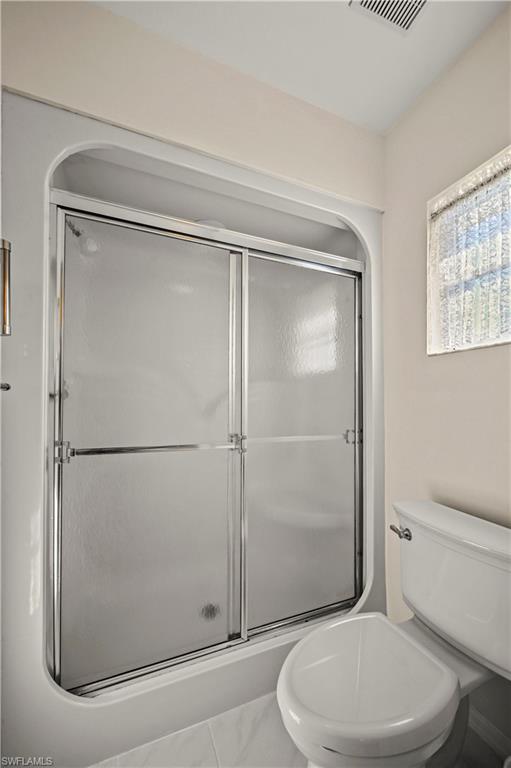 249 Gabriel Circle, Unit 12 Naples, FL 34104 - Photo 18 of 40 a white toilet sitting next to a bathroom sink