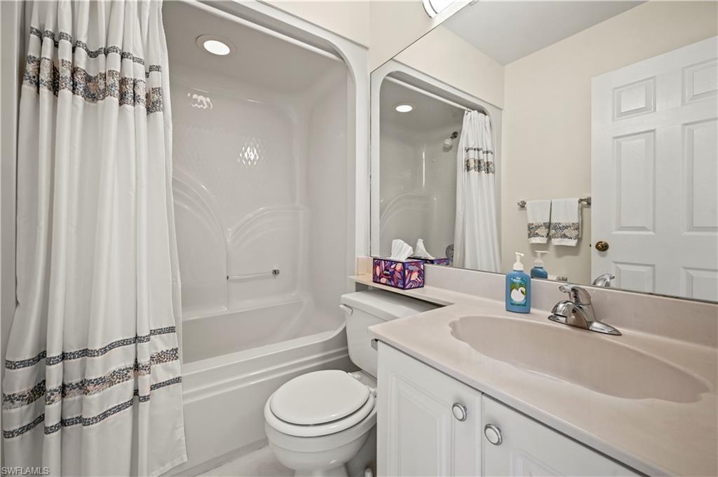 249 Gabriel Circle, Unit 12 Naples, FL 34104 - Photo 22 of 40 a bathroom with a granite countertop sink toilet and shower