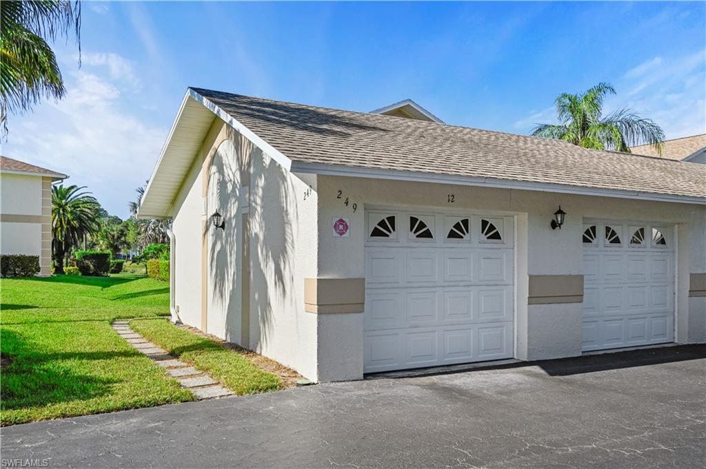 249 Gabriel Circle, Unit 12 Naples, FL 34104 - Photo 25 of 40 a front view of a house with garden