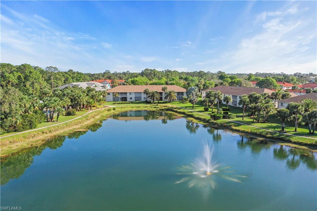 249 Gabriel Circle, Unit 12 Naples, FL 34104 - Photo 30 of 40 a view of a lake with houses in the back