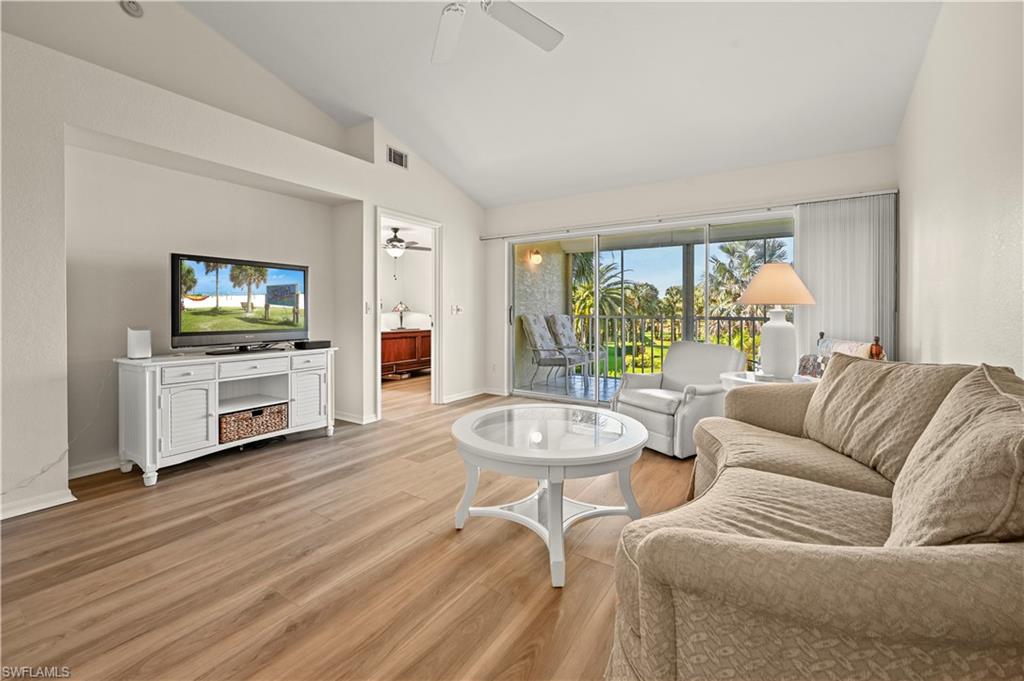 249 Gabriel Circle, Unit 12 Naples, FL 34104 - Photo 5 of 40 a living room with fireplace furniture and a flat screen tv
