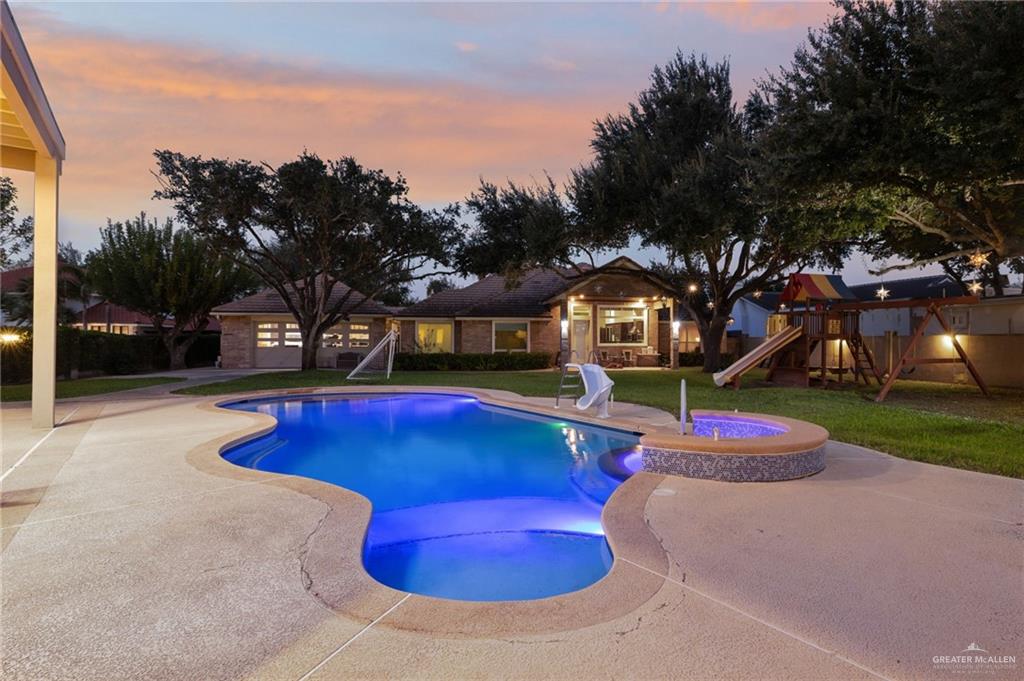 809 Rio Grande Drive Mission, TX 78572 - Photo 27 of 43 View of swimming pool with a playground, a patio, a lawn, and a pool with connected hot tub