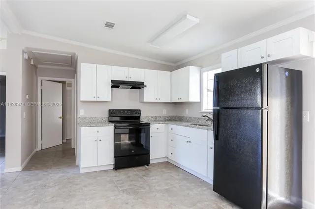a kitchen with stainless steel appliances granite countertop a refrigerator and a stove