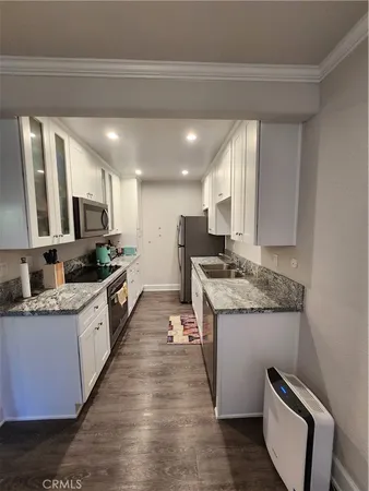 a large kitchen with stainless steel appliances kitchen island granite countertop a sink and cabinets