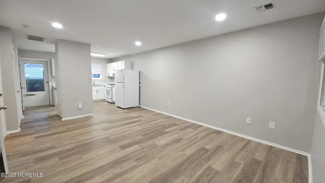 an empty room with wooden floor and window