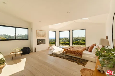 a bedroom with furniture and a large window