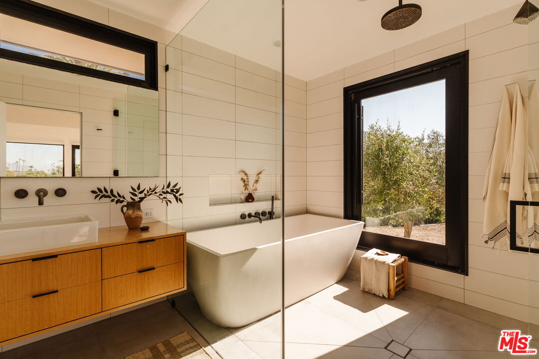 6767 Wandermere Road Malibu, CA 90265 - Photo 20 of 46 a bathroom with a tub sink and mirror
