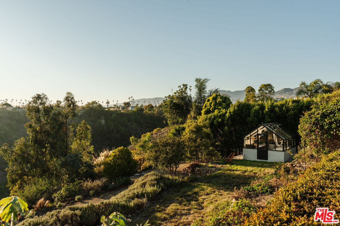 6767 Wandermere Road Malibu, CA 90265 - Photo 39 of 46 a view of a house with a yard and mountain in the back