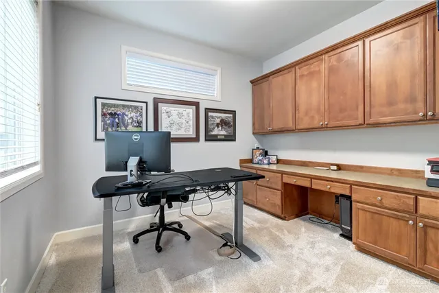a view of a workspace with furniture and a window