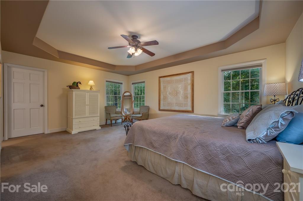 1426 Hayes Road Columbus, NC 28722 - Photo 20 of 45 a spacious bedroom with a large bed and a chandelier