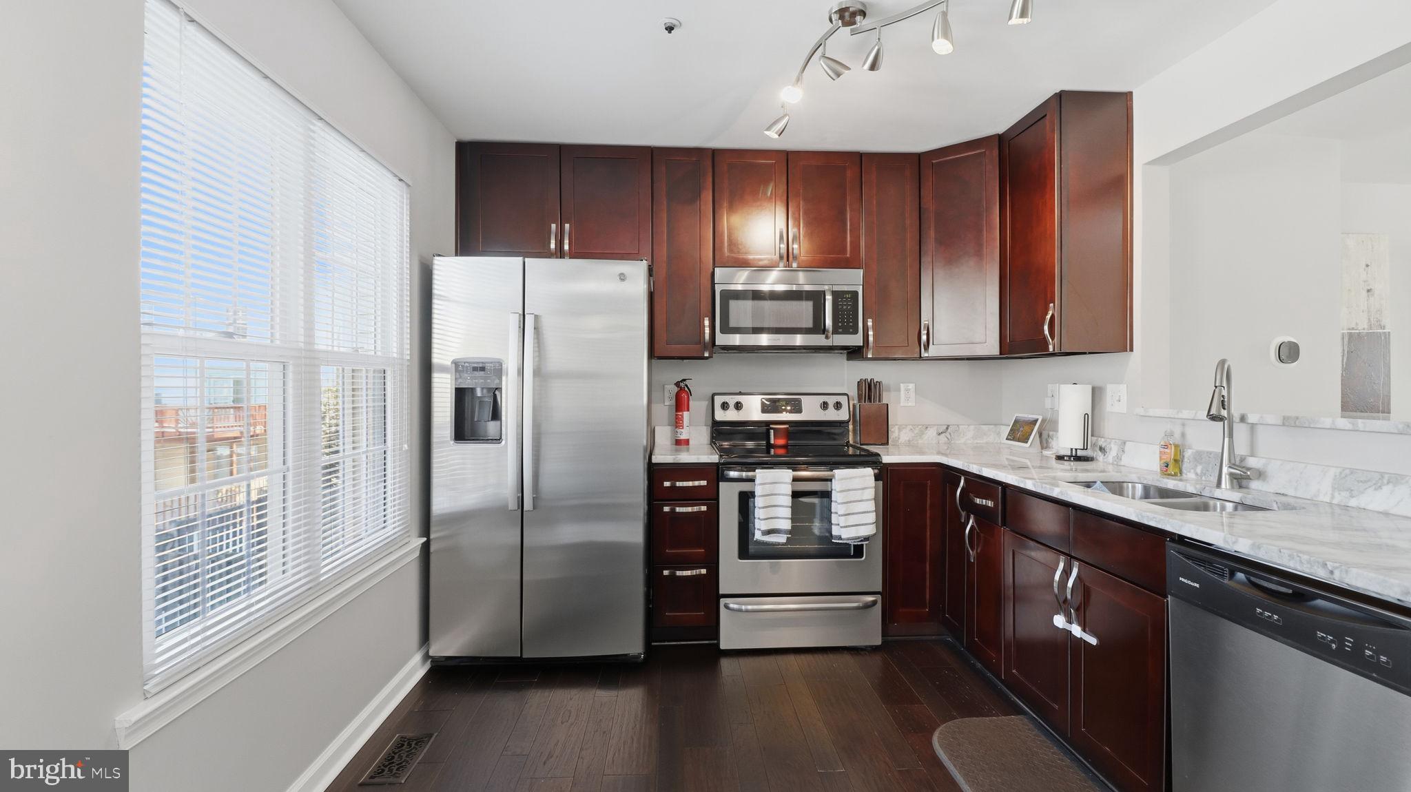 15922 Edgeview Terrace Bowie, MD 20716 - Photo 19 of 41 a kitchen with stainless steel appliances a refrigerator sink and cabinets