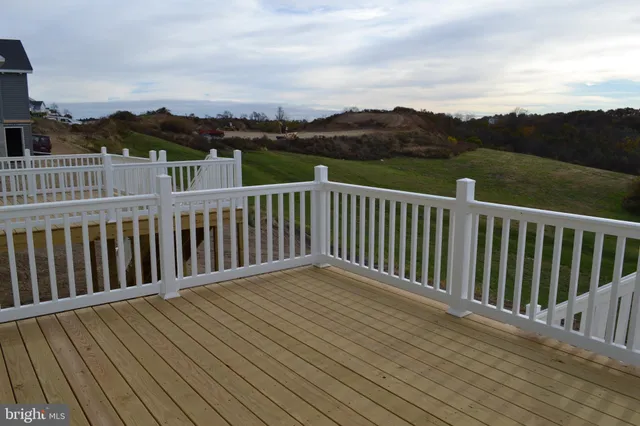 a view of a balcony with wooden floor and fence